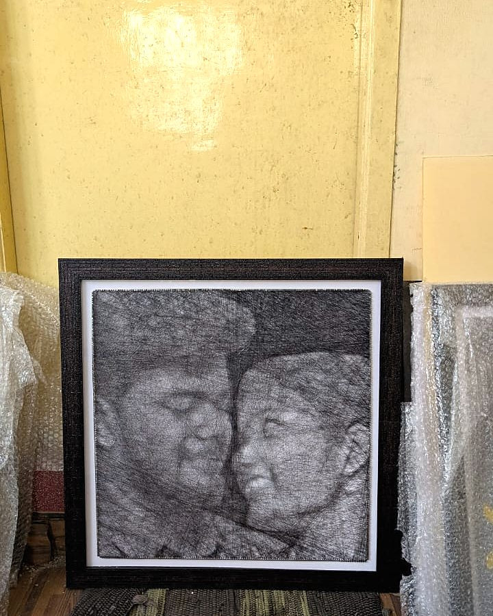 Couple thread portrait in a black glass frame