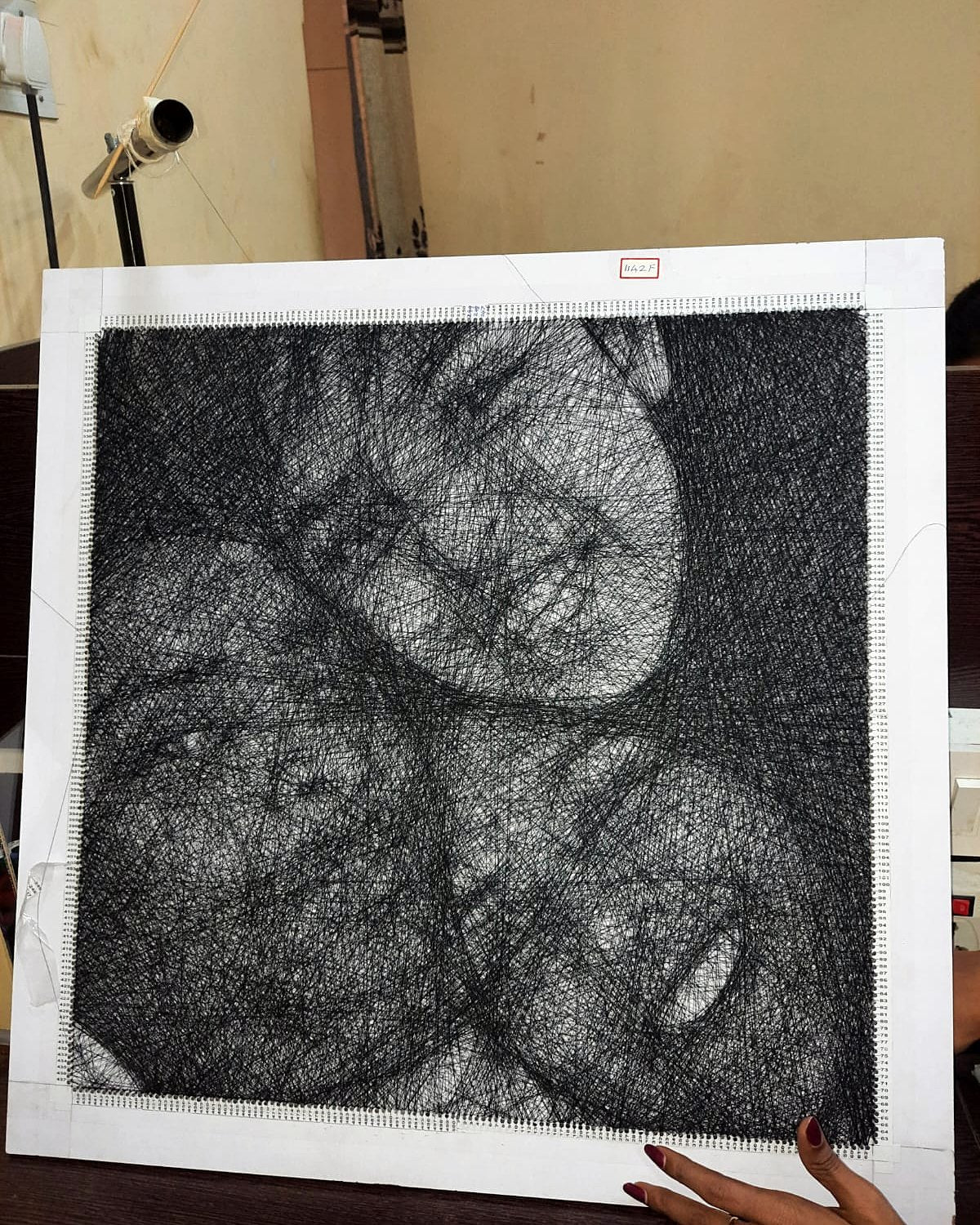 Square thread portrait with three faces
